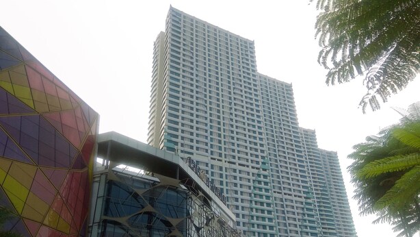 Un edificio moderno con fachada geométrica y amplia zona de ventanales.