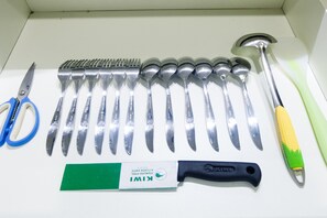 Kitchen essentials at your fingertips, including a pair of scissors, a comb, a spatula, and various knives and spoons.