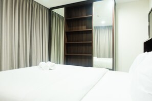 Enjoy a restful stay in this stylish room featuring a comfortable bed, ample storage, and a convenient wardrobe with mirror.