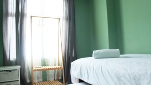Une chambre à coucher avec un lit, une table de chevet et une chaise en bois.