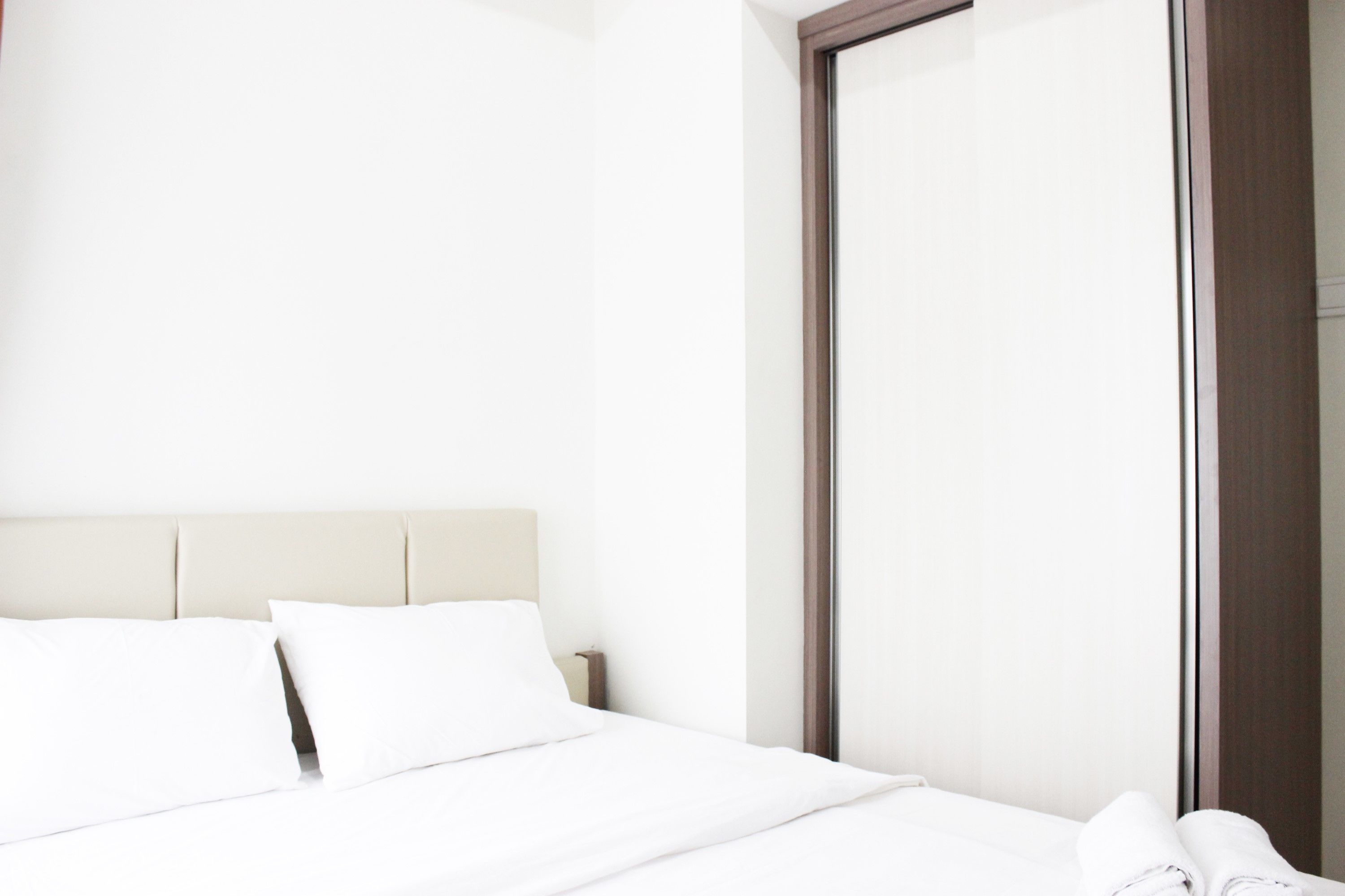 Ein Hotelzimmer mit Bett, Nachttisch und einem großen Spiegel.