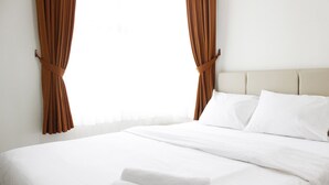 A hotel room with a bed, white linens, and brown curtains. - Cozy 2BR Apartment @ Newton Residence (Bandung)