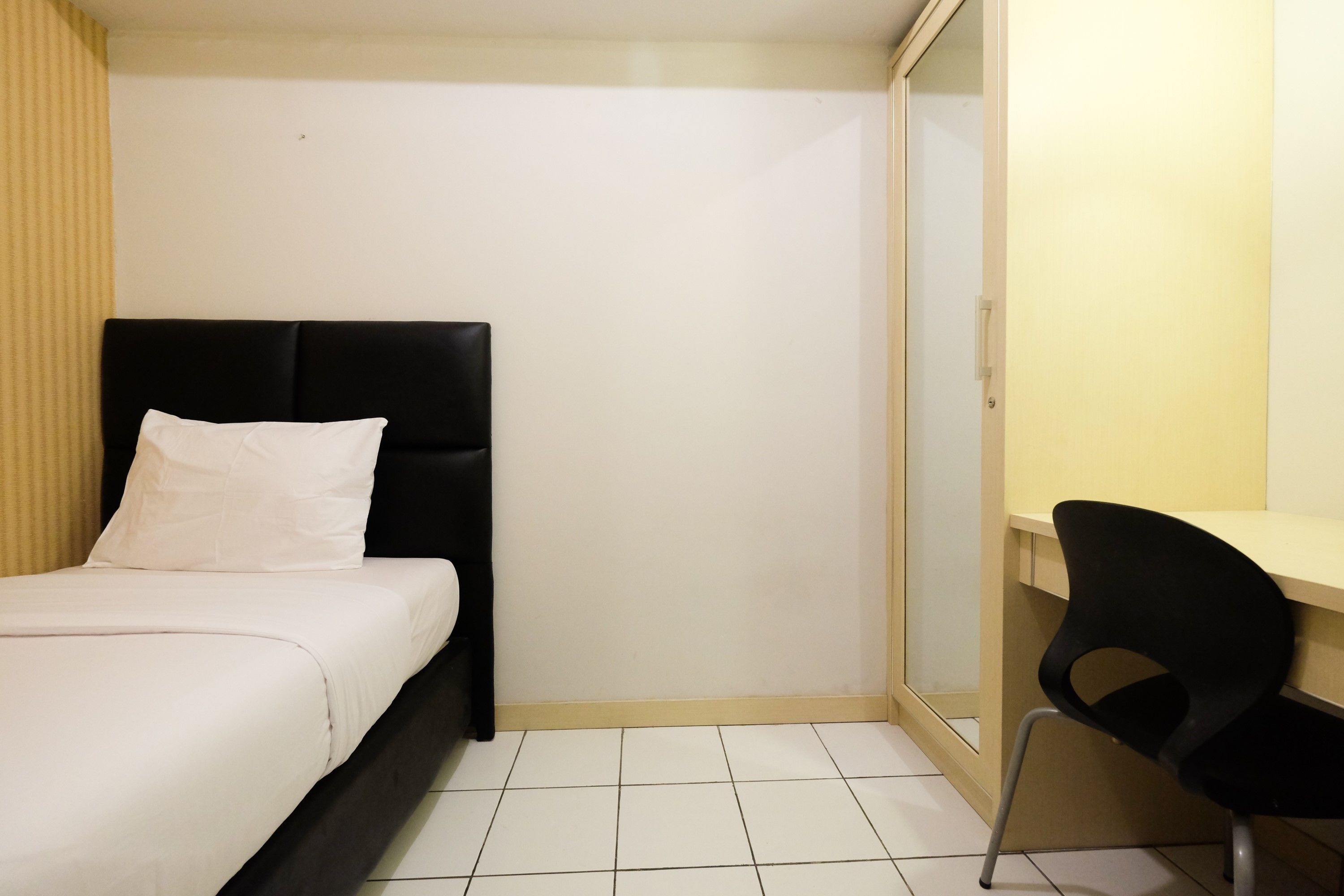 Ein Schlafzimmer mit einem Bett, einem Schreibtisch und einem Sessel.