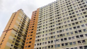 A high-rise building with multiple balconies and a uniform facade.
