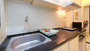 A kitchen with a double sink, a microwave, and a toaster on the counter.