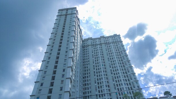 Un edificio alto y moderno, un rascacielos con muchas ventanas y balcones.
