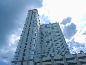 Um edifício alto e moderno, com vários andares, janelas e varandas.