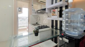 Una cocina moderna con encimera de vidrio, dispensador de agua y estufa a gas.