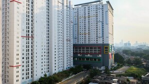 A high-rise building with multiple floors, featuring a mix of residential and commercial spaces. - Contemporary 2BR at Bassura City Apartment (Jakarta)