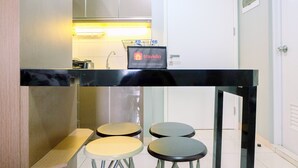 Een moderne keuken met een zwart aanrecht, vier krukken en een Travelio bord.