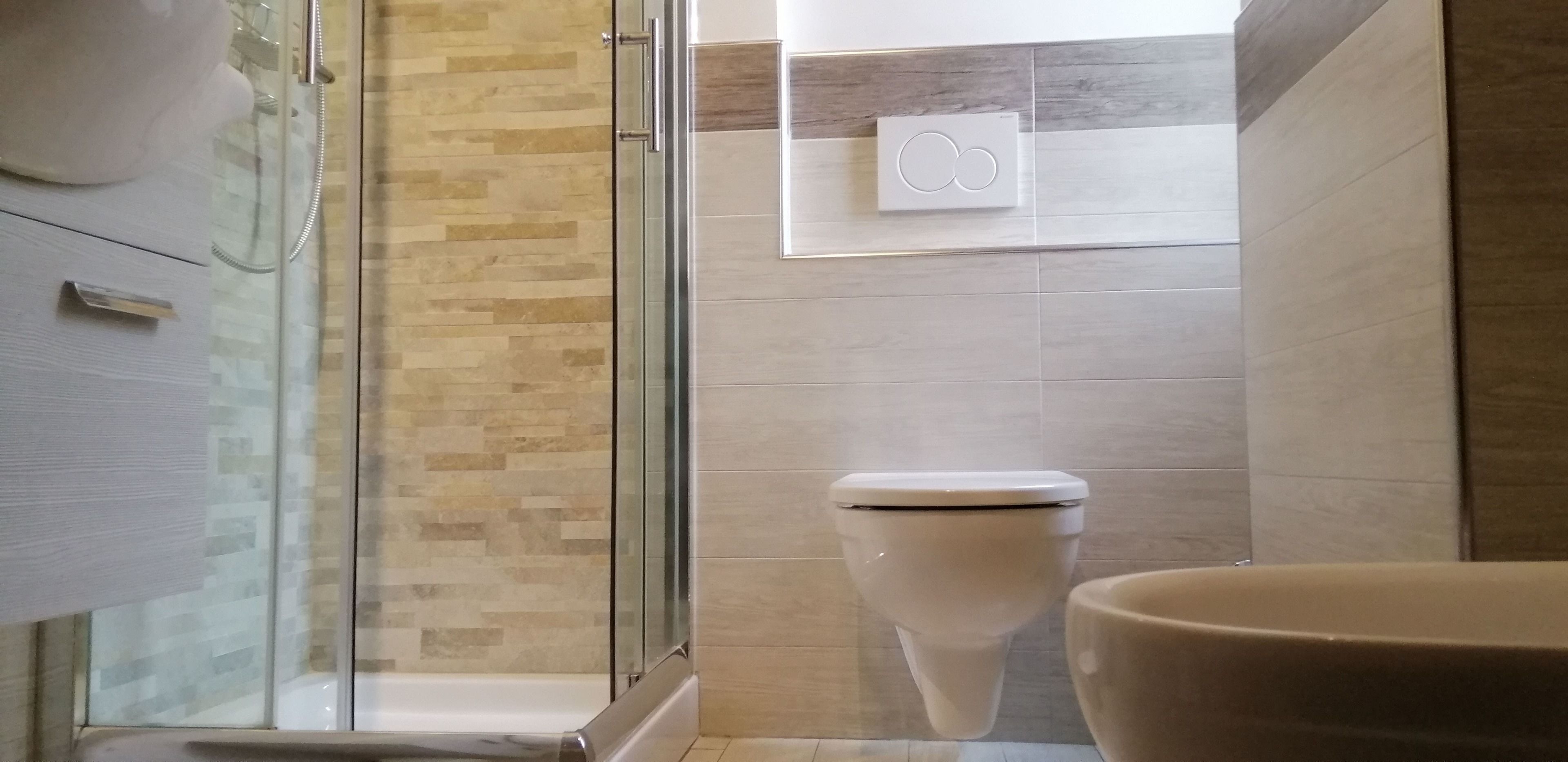Une salle de bain moderne avec une douche à parois de verre, des toilettes et un lavabo.