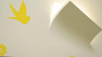 A white wall with a yellow bird decal and a partially visible yellow flower decal.