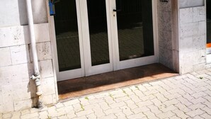 A building entrance with a glass door, a sign indicating 'Casa Aurora', and a paved walkway. - Casa Aurora B&B (Chieti)