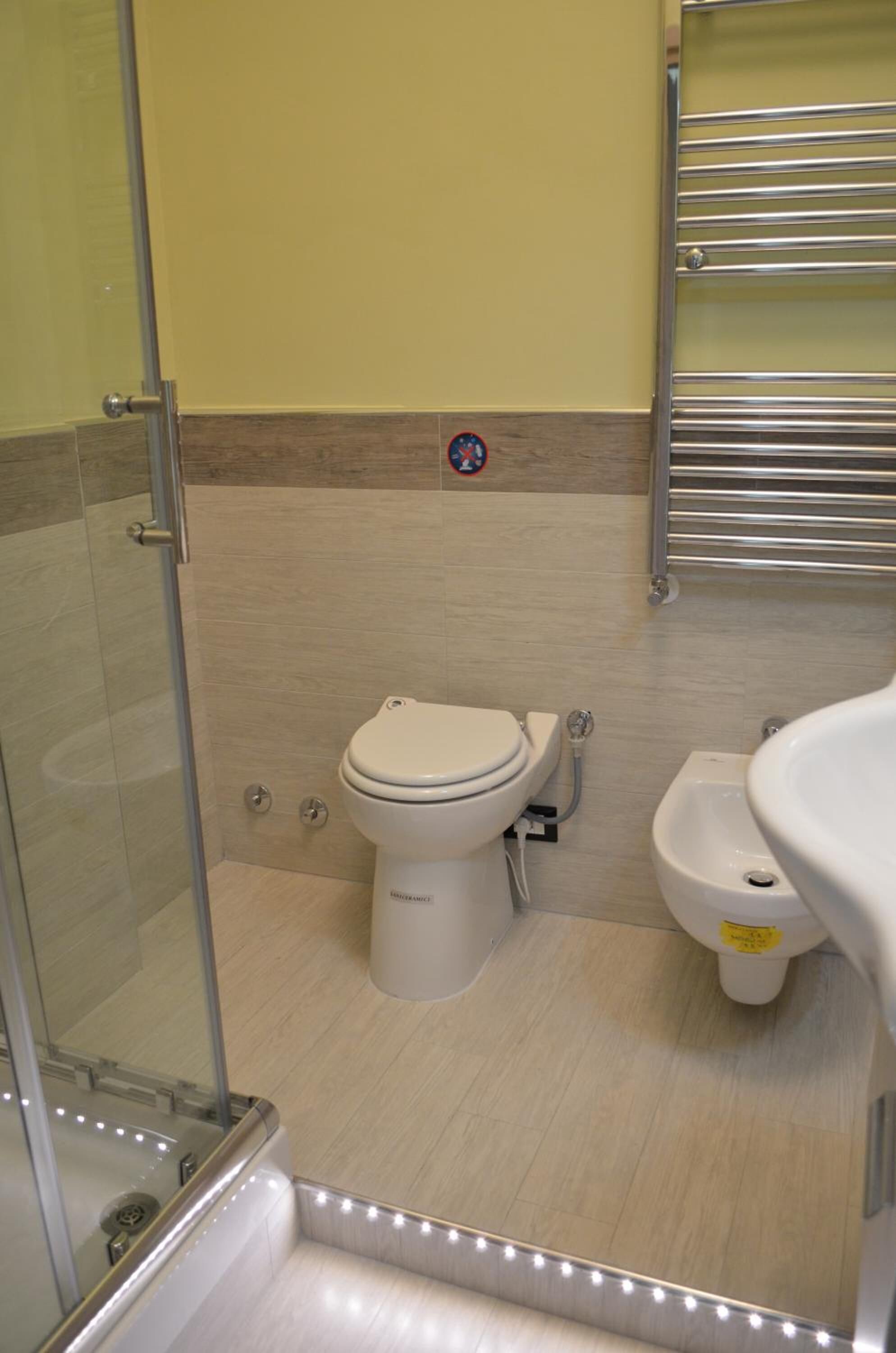 Un bagno con servizi igienici, bidet e cabina doccia in vetro.