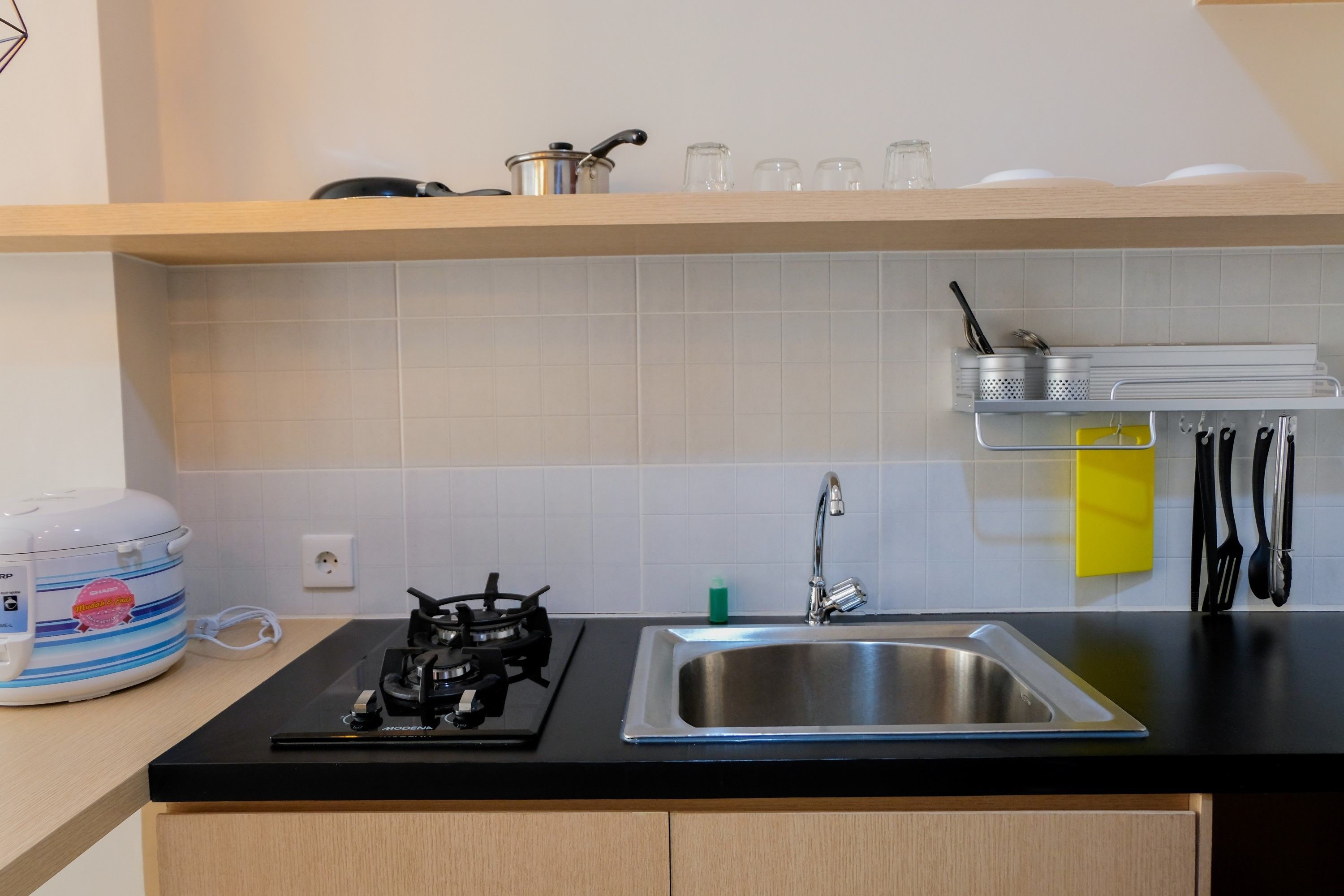 A modern kitchen with a gas stove, stainless steel sink, and a wooden countertop.