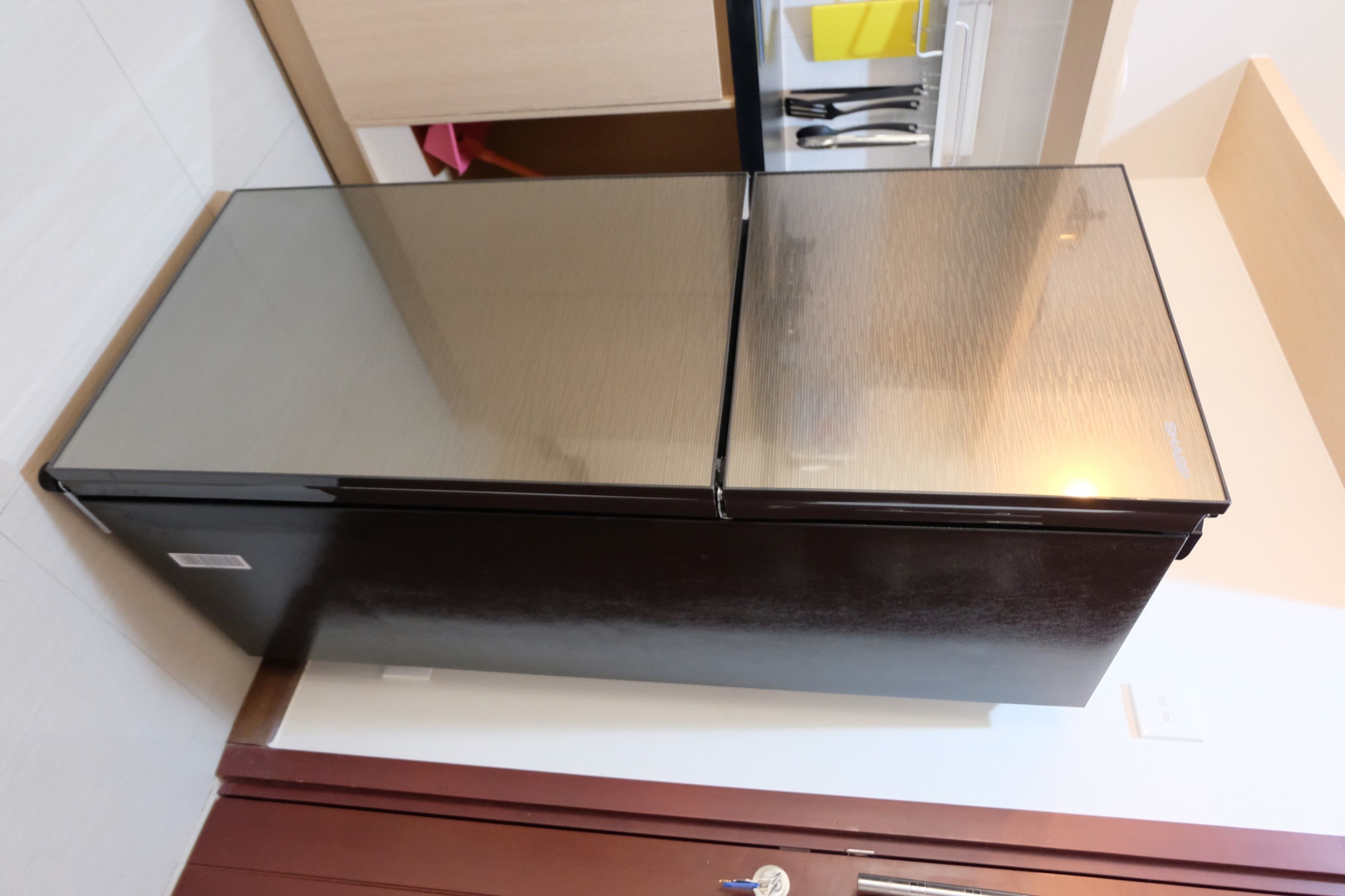 A stainless steel refrigerator with a reflective surface, placed on a white countertop.