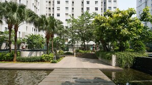 A pathway leading to a building with a water feature in the foreground.