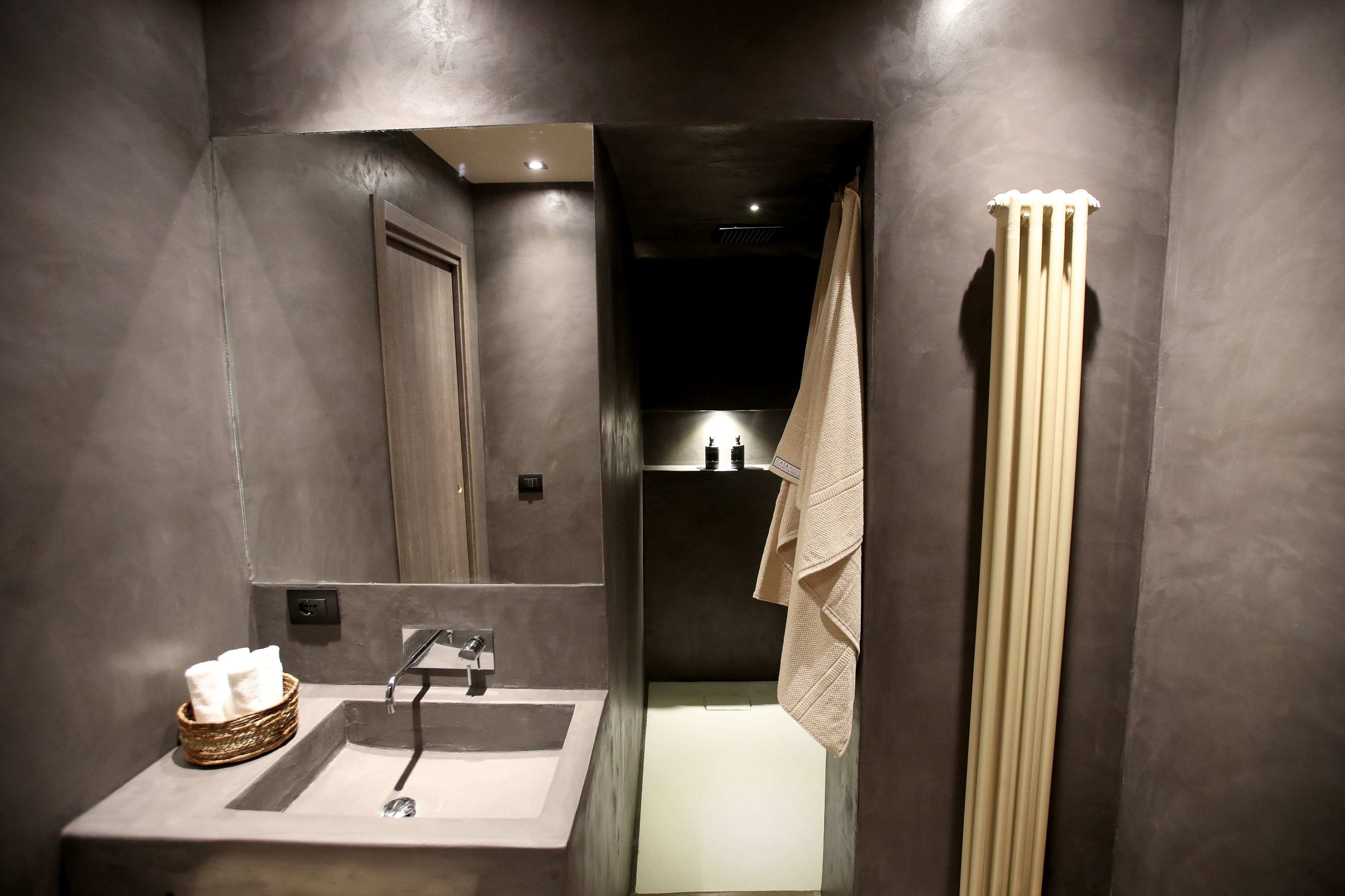 Un baño moderno con un espejo grande, un lavamanos y un perchero para toallas.