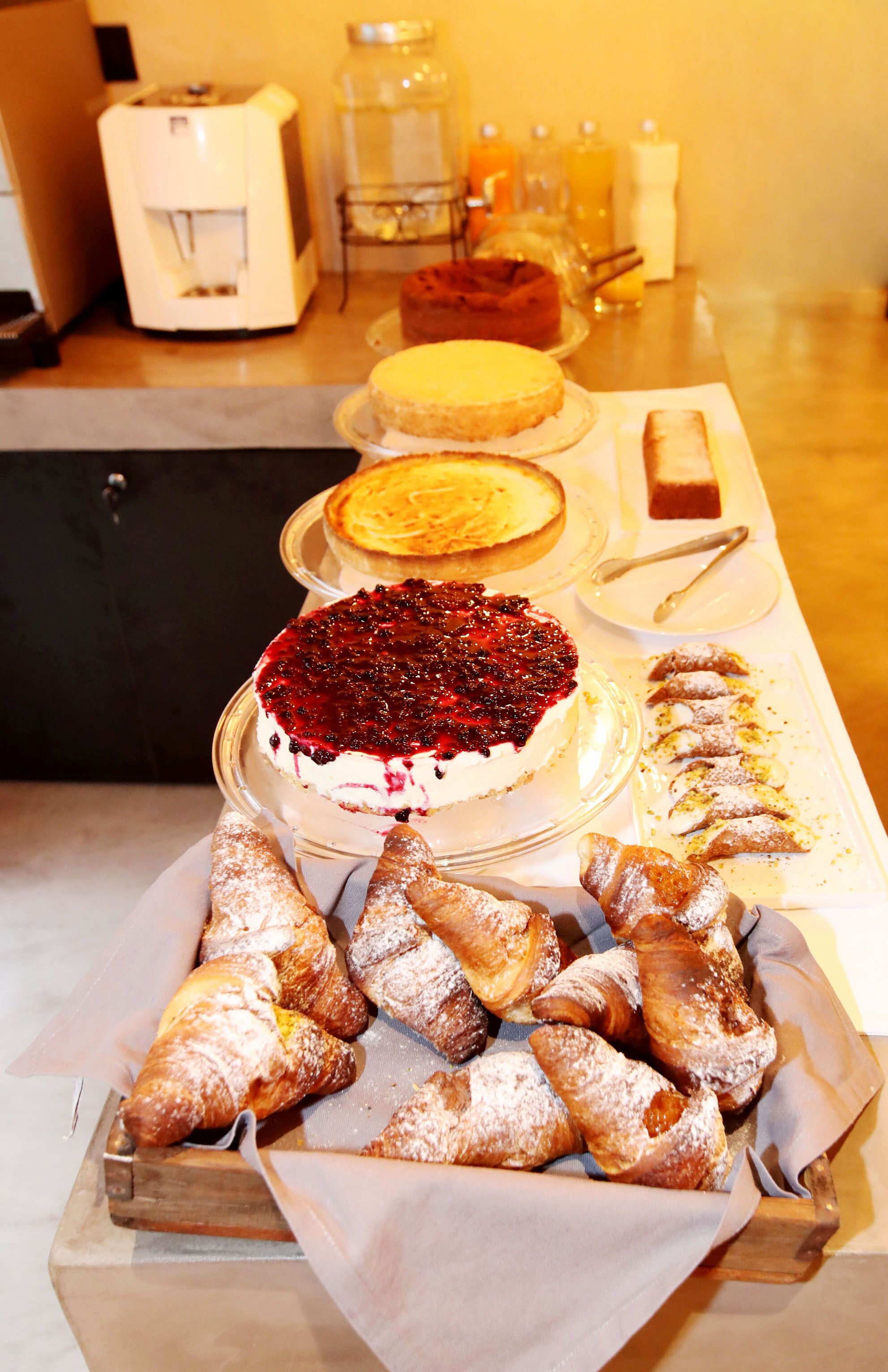 A buffet table with various desserts including cakes and pastries.