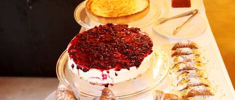 A buffet table with various desserts including cakes and pastries.