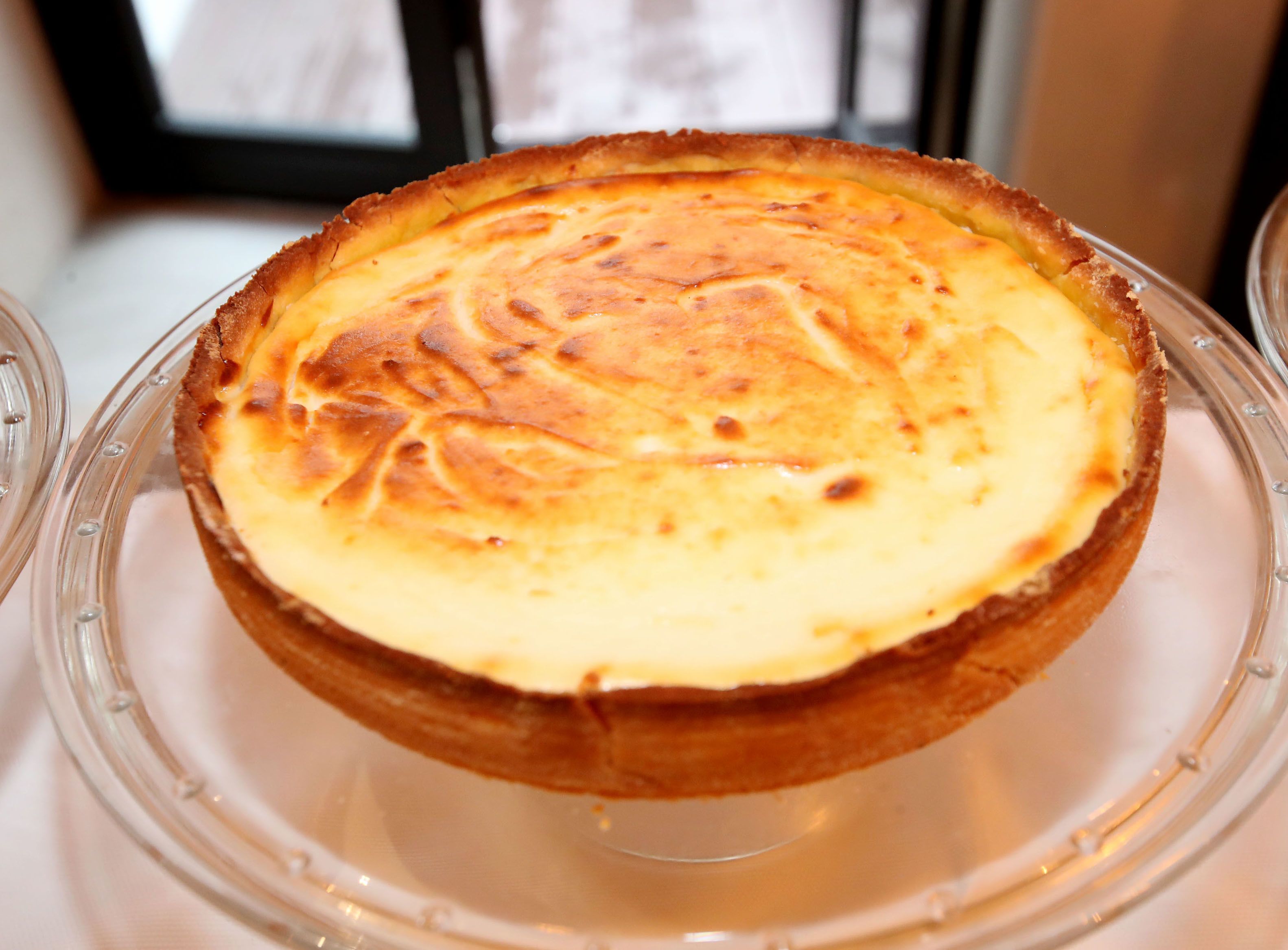 A custard tart on a clear glass plate.