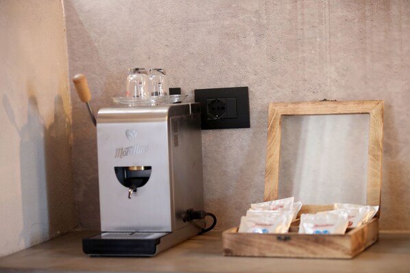 Una cafetera con estructura de madera y cápsulas de café sobre una mesa.