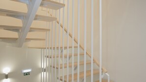 Eine moderne Treppe mit Holzbeschlägen und weißen Geländern.