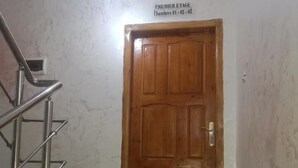 A wooden door with a sign above it reading "PREMIER ETAGE Chambres 01 - 02 - 03". - Hotel Djhaltia (Ténès)