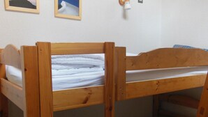 A bunk bed with a wooden frame and white bedding. - Champagny-en-Vanoise: 5-room apartment, 8 pers, pets allowed (Champagny-en-Vanoise)