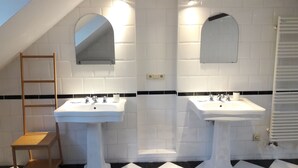 A bathroom with two sinks, a mirror, and a towel rack. - Chez Esmara Et Philippe Maisonette (Brussels)