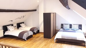 A modern bedroom with two beds, wooden flooring, and a sloped ceiling. - Chez Esmara Et Philippe Maisonette (Brussels)