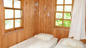 A wooden room with two beds, large windows, and a curtain. - Olympos Alaturka Pansiyon (Kumluca)