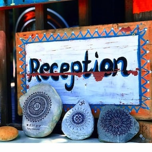 A wooden sign with the word "Reception" and three decorated stones with intricate patterns. - Olympos Alaturka Pansiyon (Kumluca)