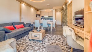 Un salon moderne avec un canapé, une table basse et un téléviseur.