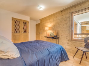 A bedroom with a bed, wooden walls, a window, and a nightstand with a lamp. - 4* Apartment at the foot of slopes, 4 pers, Wifi (Champagny-en-Vanoise)