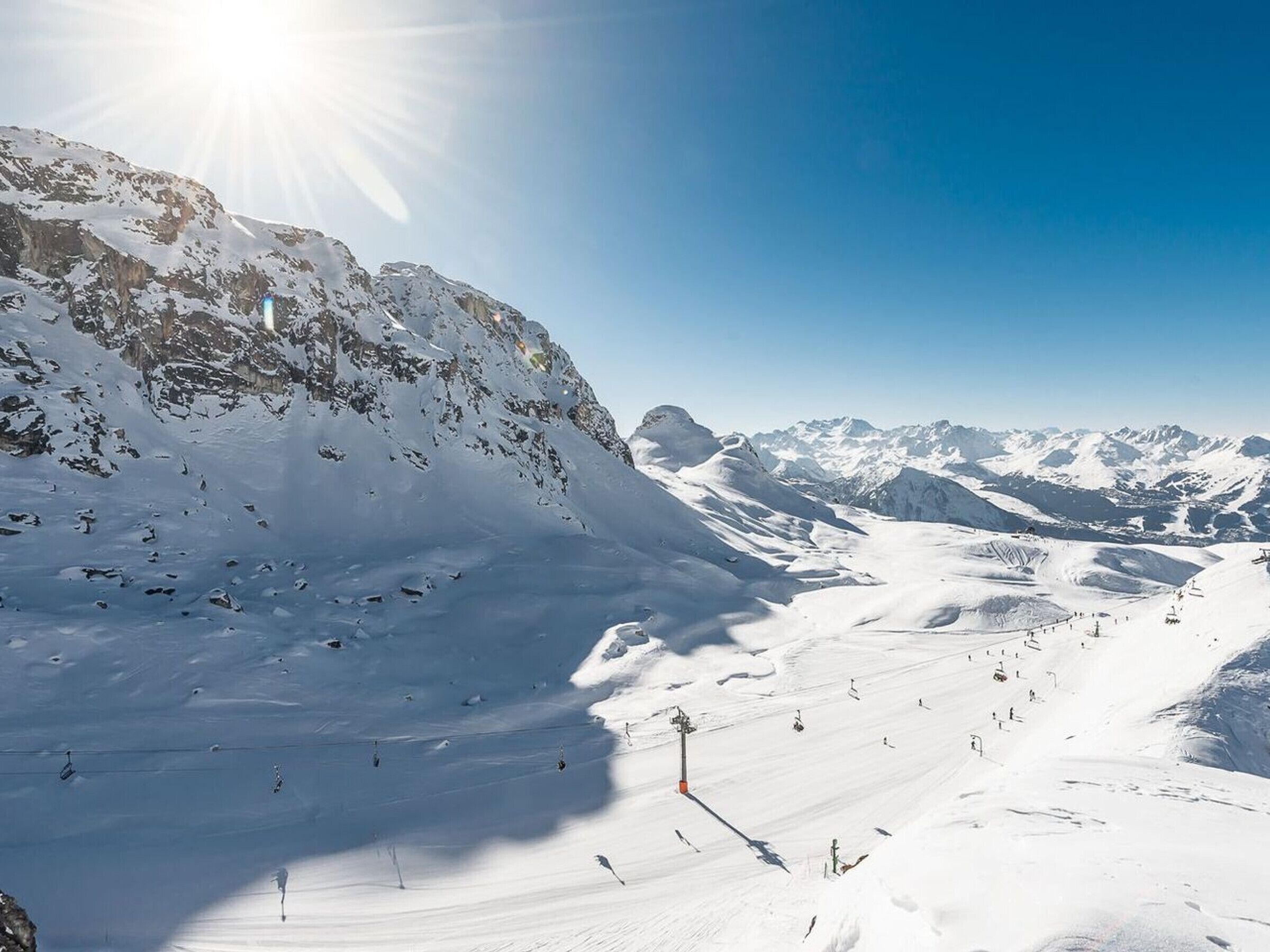 A snow-covered mountain landscape with ski slopes and a ski lift.