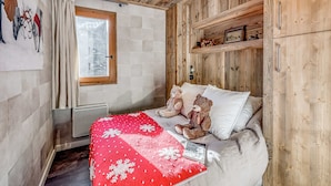 A cozy room with a wooden ceiling, a bed with a red blanket, two teddy bears, and a window with a view of a snowy landscape. - Champagny en Vanoise - Renovated 2-room, 6 pers, balcony, WIFI (Champagny-en-Vanoise)