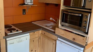 A compact kitchen with a coffee maker, a microwave, and a dishwasher.