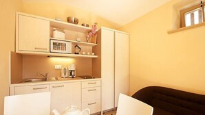 A compact kitchen with a sink, a coffee maker, and a teapot on the counter. - FeWo Leibnizallee (Weimar)