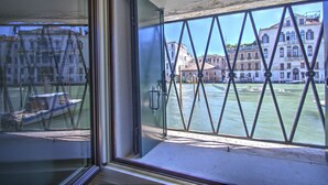 A window with a view of a canal, buildings, and a boat. - GrandCanal-Red (Venice)