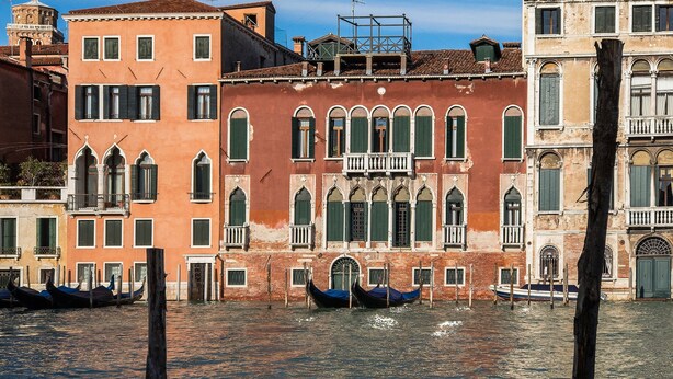 A canal with gondolas and historic buildings with balconies and arched windows. - GrandCanal-Red (Venice)