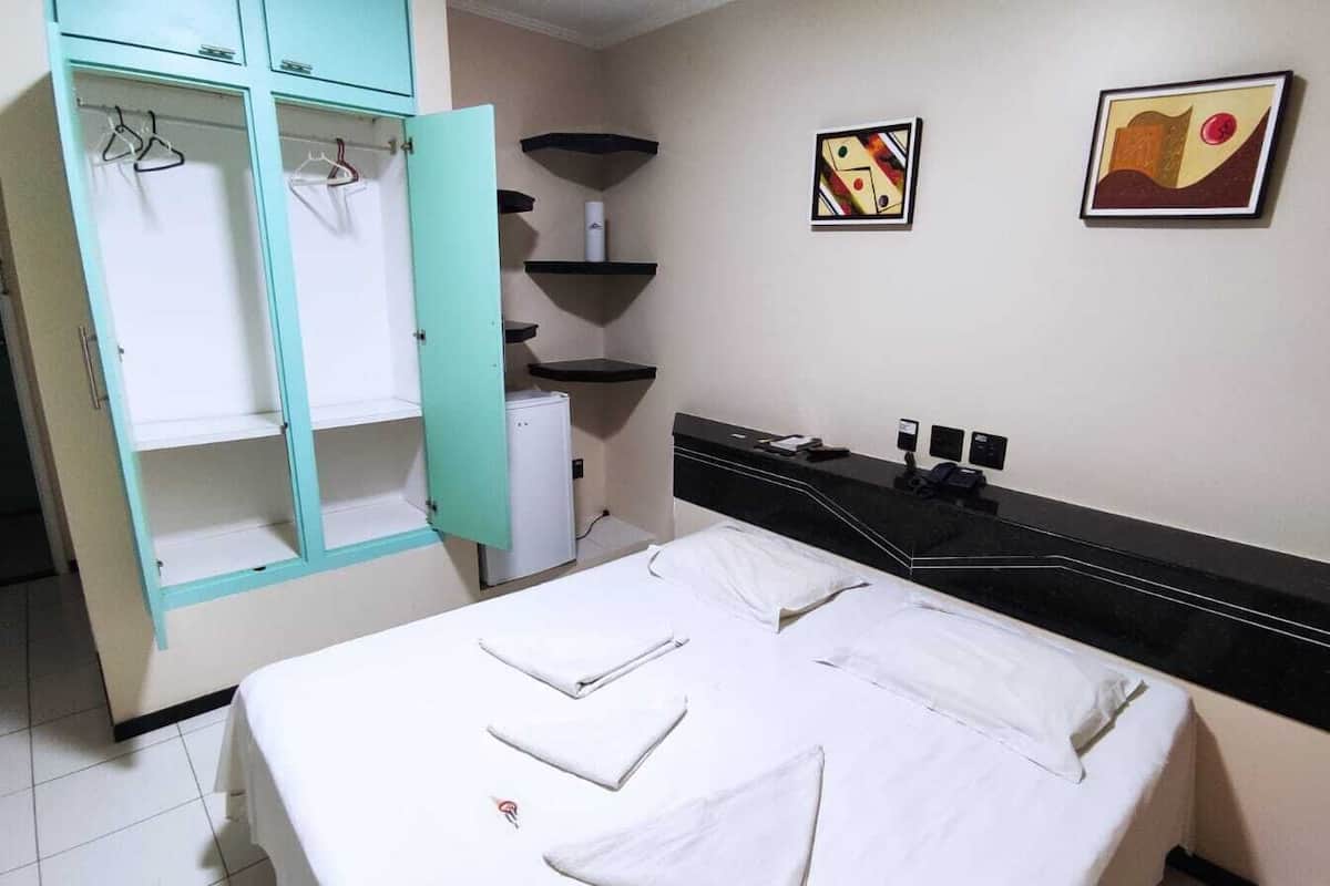 Minibar, escritorio, cortinas blackout y tabla de planchar con plancha
