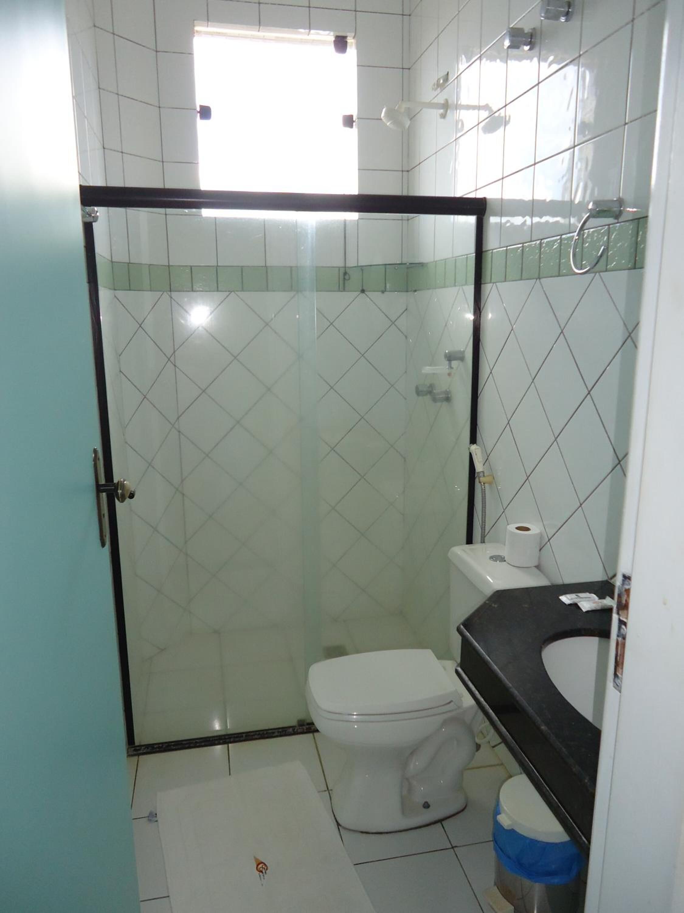 Un baño pequeño con inodoro, lavamanos y cabina de ducha.
