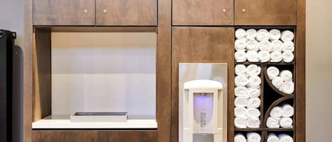 A wooden cabinet with a built-in water dispenser and towel storage.