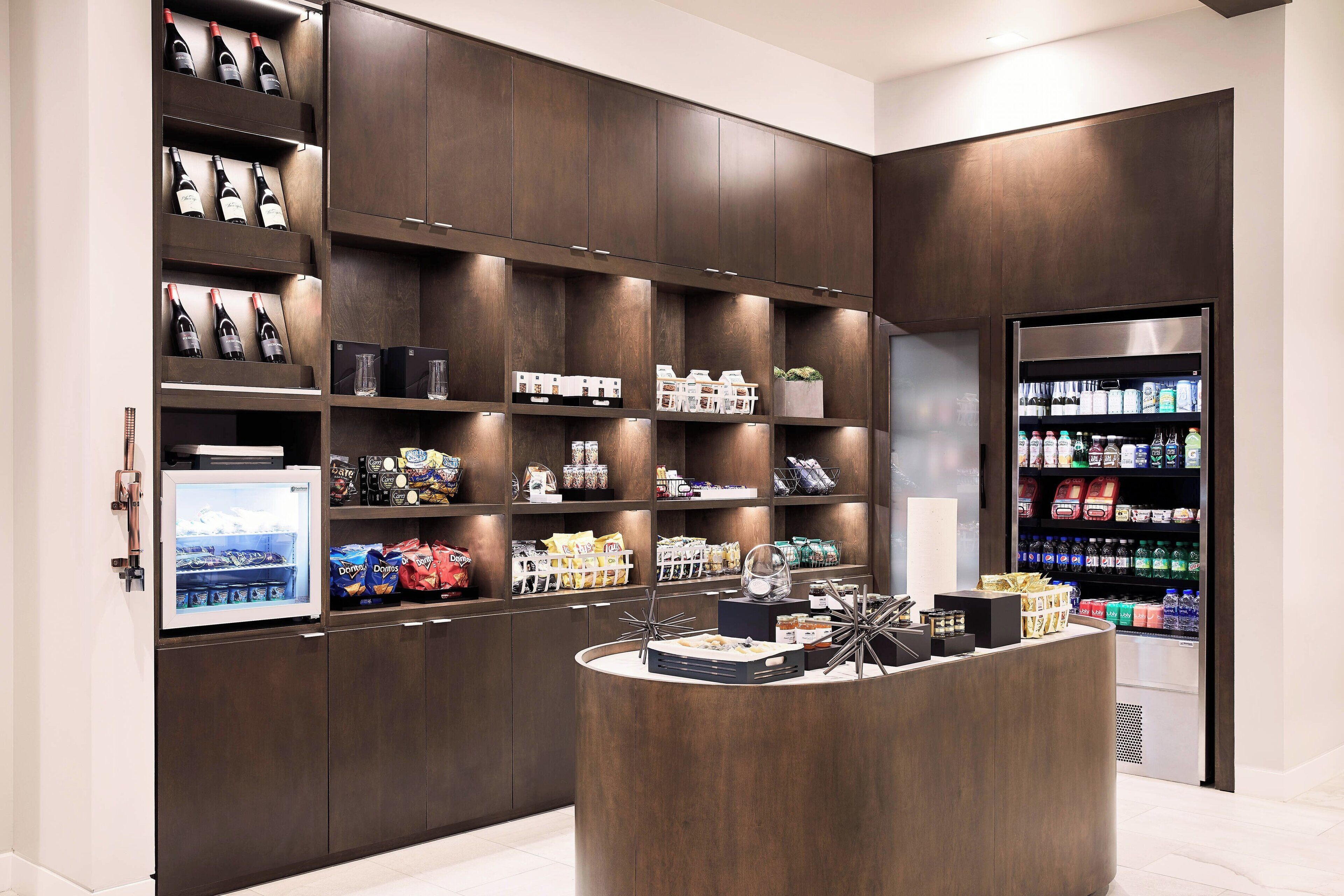Un garde-manger moderne dans un hôtel, proposant du vin, des collations et des boissons.