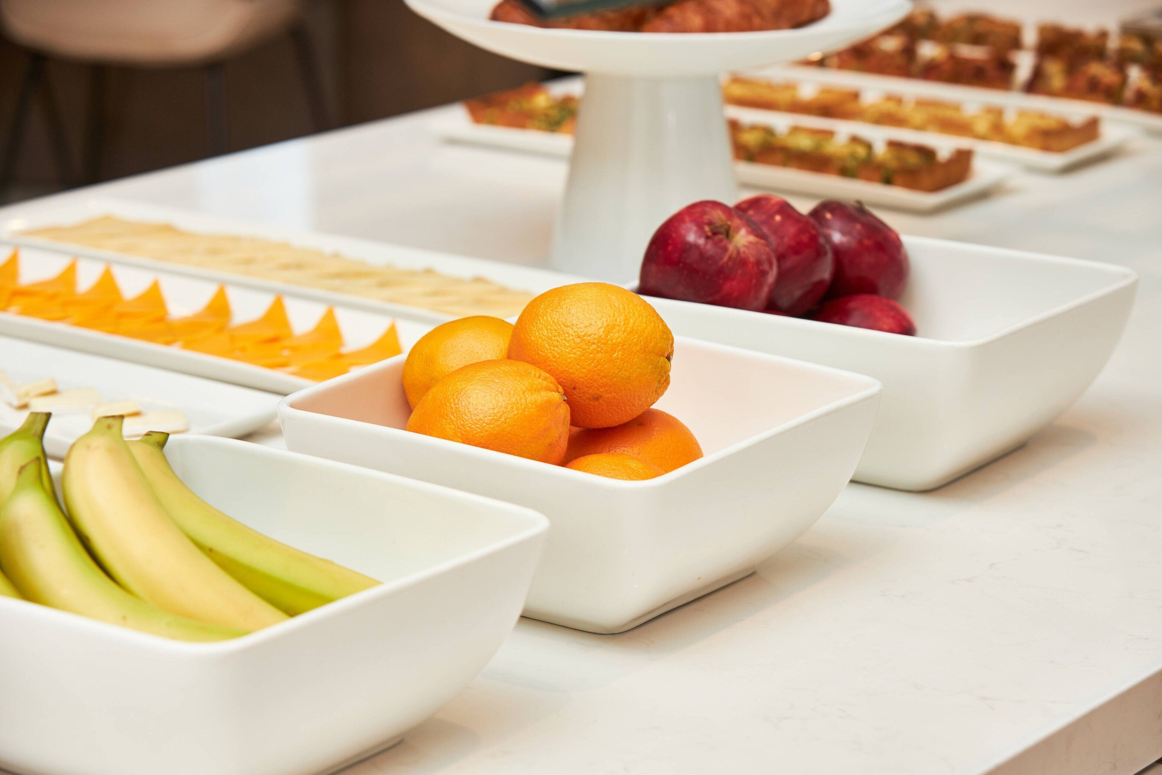 A buffet table with various fruits and pastries.