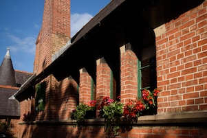 A brick building with a prominent tower and arched windows.