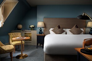 A hotel room with a large bed, two nightstands, a round table, and a chair. - Schoolhouse Hotel (Dublin)