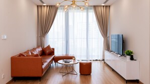 Ein modernes Wohnzimmer mit einer Ledersofa, einem Couchtisch und einem Fernseher auf einer Kommode.