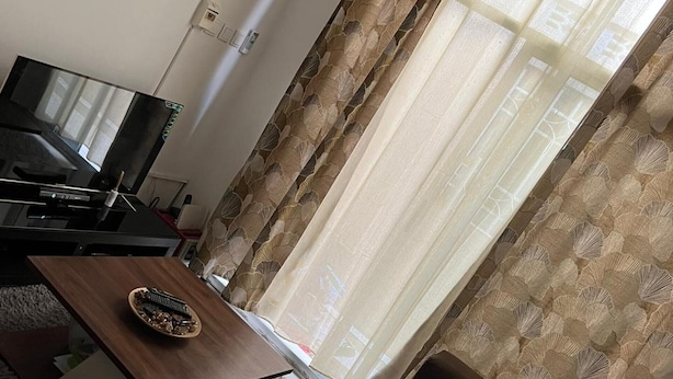 A living room with a flat-screen TV, a wooden coffee table, and a sofa. - BCBG KinShasa Apartment (Limete)